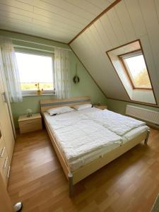 ein Schlafzimmer mit einem großen Bett im Dachgeschoss in der Unterkunft Haus Paradieskoppel 9223 - Bannesdorf in Niendorf