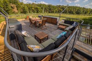 Nowawieś ZbąskaにあるWater Hideout - Floating Villas in Wild Natureのソファとテーブル付きのデッキ