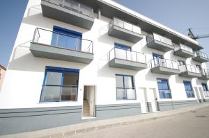 - un bâtiment blanc avec des fenêtres et des balcons bleus dans l'établissement Livingtarifa Apartamento Blue II, à Tarifa