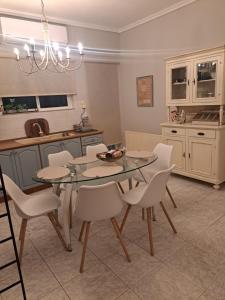 FaraíAvras experiense 6的配有玻璃桌和白色椅子的厨房 更多10张照片