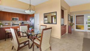 a dining room and kitchen with a glass table and chairs at Kapalua Ridge Villa 1721 in Kapalua