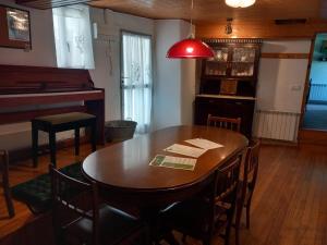 a dining room with a table and a piano at A casa da Cernada in Rocas