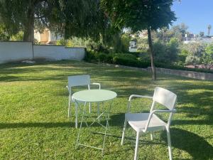 two chairs and a table in a yard at Hotel Brillante 156 in Córdoba