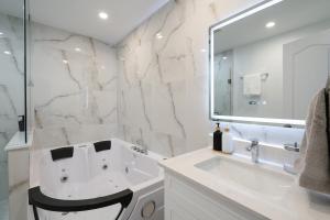 a white bathroom with a sink and a mirror at Luxury 2 Bedroom 3 Bed Family Friendly Oasis with Smart Technology in Brampton