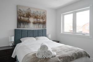 a bedroom with a bed with two towels on it at Luxury 2 Bedroom 3 Bed Family Friendly Oasis with Smart Technology in Brampton