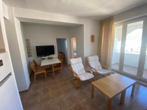 a living room with a television and a table and chairs at Casa Clara in Ohrid
