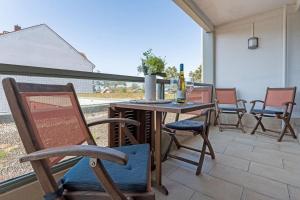 沙博伊茨Haus Meeresstrand Wohnung 106的庭院配有椅子和一张桌子及一瓶葡萄酒