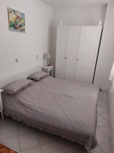 a bedroom with a large bed with white cabinets at Apartment Milano in Matulji