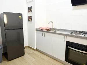 Una cocina con frigorífico de acero inoxidable y fregadero. en DakarByDays DBD011 Appartement Astou 3 chambres, en Dakar