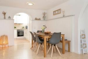 a kitchen and dining room with a wooden table and chairs at Dünenbungalow in Grömitz