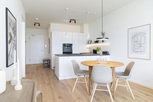 a kitchen and dining room with a table and chairs at Eichenhain Saltkrokan in Pelzerhaken +45 photos