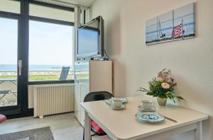 a living room with a table and a tv at Stranddistel 7 Ostseezauber in Burgtiefe auf Fehmarn  +11 photos