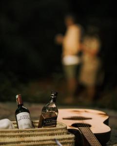 two bottles of wine in a basket with a guitar at Barangata collections in Barangata