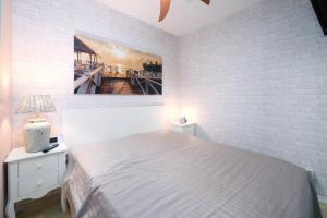 ブラズィリアンにあるMien Leevの白いベッドルーム(ベッド1台付)が備わります。壁には絵画が飾られています。