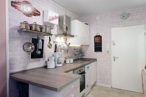 ブラズィリアンにあるMien Leevの白い壁のキッチン(木製カウンタートップ付) +3枚の写真
