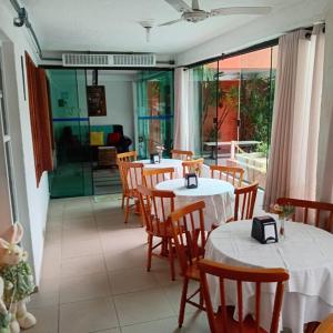 a restaurant with two tables and chairs with white table cloth at Pousada Gaivotas do Guaraú in Peruíbe +36 photos
