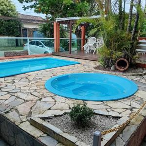 una piscina en un patio con un patio de piedra en Pousada Gaivotas do Guaraú, en Peruíbe