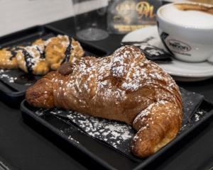 a tray with two pastries and a cup of coffee at Domus Monasteire in Pagani