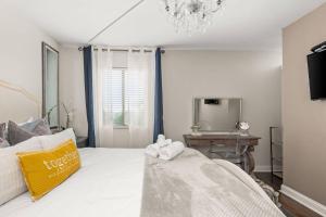 ein Schlafzimmer mit einem weißen Bett und einem Spiegel in der Unterkunft Riverfront 786 in Nashville + 35 Fotos