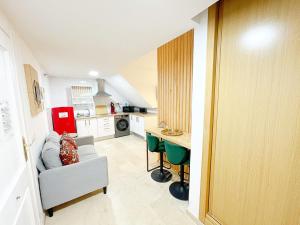 een woonkamer met een bank en een keuken bij NEW Tropic Malaka Home in Málaga