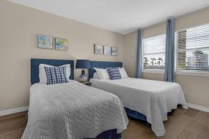 a bedroom with two beds and a window at Beach on a Budget by Gulf Coast Getaways in Navarre +28 photos
