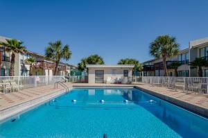 a swimming pool in a courtyard with palm trees at Beach on a Budget by Gulf Coast Getaways in Navarre
