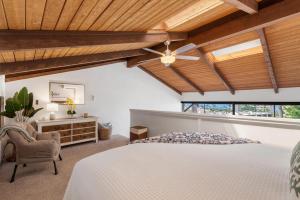 een slaapkamer met een wit bed en een houten plafond bij Perch - Alii Kai Loft in Kihei +25 foto's