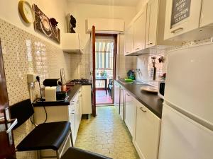 une cuisine avec des armoires blanches et un réfrigérateur dans l'établissement Penthouse Salus sea view terrace, à Lido di Ostia