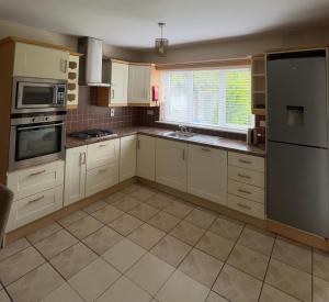 a large kitchen with white cabinets and appliances at Serene Home in Ennis