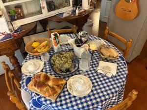 a table with a blue and white checkered table cloth with breakfast foods at Penelope B&B in Palermo +40 photos