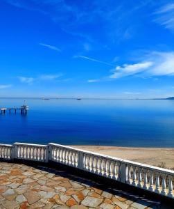 una valla blanca en la playa cerca del agua en AURA BEACH apartment, en Burgas