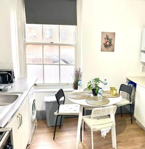 a kitchen with a table and chairs in a kitchen at Shoreditch Rooms Near Tower Bridge in London