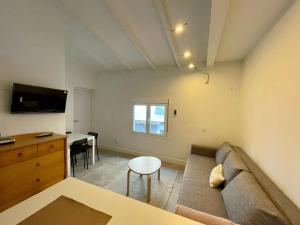 a living room with a couch and a table and a desk at Casthotels Leblon in El Arenal