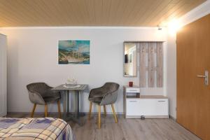 - une chambre avec une table, deux chaises et un lit dans l'établissement Leuchtturm Dreangel, à Heikendorf