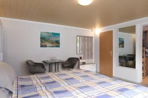 une chambre avec un lit, une table et des chaises dans l'établissement Leuchtturm Dreangel, à Heikendorf 4 autres photos