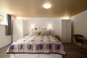 une chambre avec un lit avec une couverture à carreaux dans l'établissement Leuchtturm Dreangel, à Heikendorf