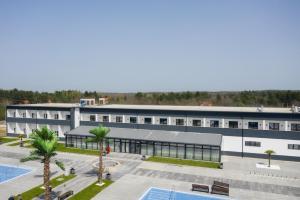 an office building with a swimming pool and palm trees at Sand City in Železnička Stanica Dolovo