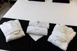 a group of white towels on a bed at Sand City in Železnička Stanica Dolovo