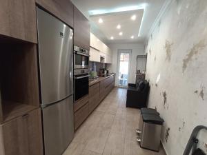 a kitchen with a stainless steel refrigerator and wooden cabinets at Judy-lak Apartman in Nyíregyháza