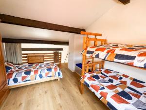 two bunk beds in a room with wooden floors at Escale aux tropiques - Vue mer in Saint Cyprien Plage +28 photos
