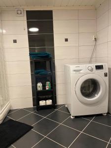 a laundry room with a washing machine in it at FREDNES COSY RETREAT - One Bedroom Apartment in Porsgrunn +3 photos