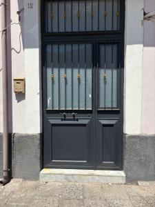 una puerta negra en un edificio con en La casa di Giorgia, en Catania 3 fotos más