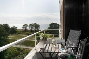a balcony with a table and two chairs and the ocean at Hanseat Wohnung 185 in Grömitz