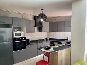 a kitchen with stainless steel appliances and a red stool at Alger - Dely Ibrahim - Appartement moderne et cosy in Deli Ibrahim +5 photos