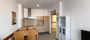 a kitchen with white walls and a table and chairs at Enebrales 423 in Punta Umbría