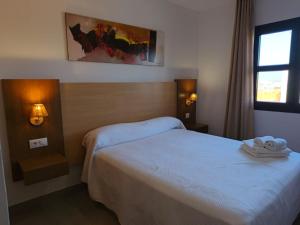 a hotel room with two beds and a window at Enebrales 423 in Punta Umbría +38 photos