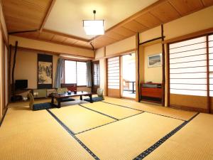 una sala de estar con una alfombra grande en el suelo en Kaneki Hotel, en Yamanouchi