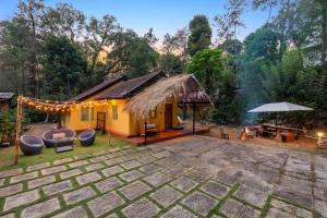 una casita amarilla con un patio y una tienda de campaña en Sliceinn Somewhere Together In Biligeri, en Madikeri