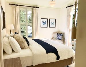 a bedroom with a large bed with pillows and a window at Mirrabella Blue Mountains Boutique Getaway in Blackheath