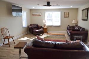 a living room with a leather couch and chairs at 4BR Historic Home Private Dock Fishing in Davis